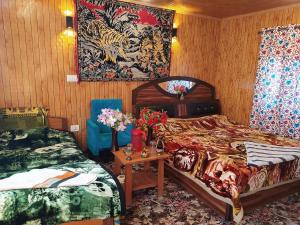 斯利那加H.B Holiday home的一间卧室配有两张床和一张鲜花桌