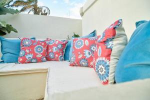 阿鲁沙The Hatua Peaceful Homeaway Haven的白色的沙发,上面有蓝色和红色的枕头