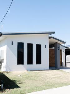 麦凯New Home close to Airport hospital Coles & Resto的黑窗 ⁇ 染白色房子