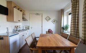 蒙尼肯丹Farm Overleekerhoeve的厨房配有木桌和椅子