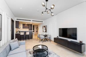 迪拜Nasma Luxury Stays - Elegant 1BR With Stunning View of Park Avenue的带沙发和电视的客厅