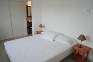 维琪奥港Résidence Tamaris 2的一间卧室配有白色床和2个床头柜