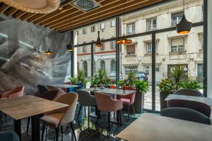 布达佩斯Onyx Luxury Budapest的餐厅设有桌椅和窗户。