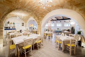 滨海库普拉Camping Villaggio Calypso的餐厅设有白色的桌子和黄色的椅子