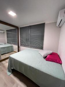 托雷斯Apto duplex Lagoa do Violão的一间带一张大床的卧室,位于带窗户的房间内
