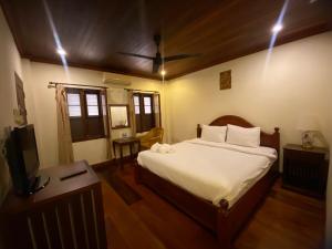 琅勃拉邦somvang khily guesthouse 宋旺吉利 酒店的一间卧室配有一张床和一台电视。