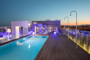 马拉加马拉加巴瑟罗酒店的夜间在建筑物屋顶上的游泳池