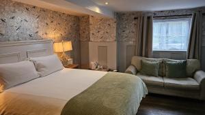 埃文河畔斯特拉特福College Arms的一间卧室配有一张床、一张沙发和一个窗口