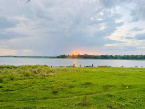 波隆纳鲁沃Hotel Lake Park的享有远处湖泊和太阳的美景