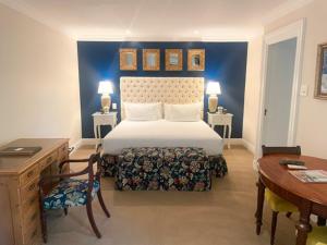开普敦安德罗斯精品酒店的一间卧室配有一张床、一张桌子和一张桌子