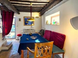 巴尼奥雷焦Accogliente Dimora Panoramica Civita di Bagnoregio的一间配备有蓝色桌子和红色椅子的用餐室