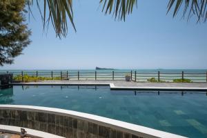 马勒勒角Luxury beachfront duplex, Coin de Mire view / 3Bed的一座背景海洋的游泳池