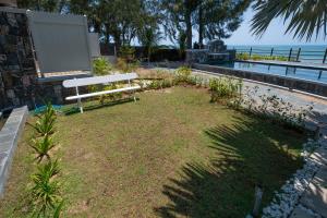 马勒勒角Luxury beachfront duplex, Coin de Mire view / 3Bed的坐在水边的草地上的公园长凳