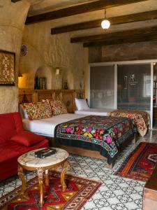 格雷梅卡帕多西亚卡内拉卡威酒店的一间卧室配有两张床和一张红色沙发