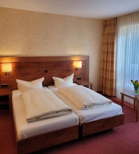 伯格奥夫费马恩NP Hotel Wissers的卧室配有带白色枕头的大床