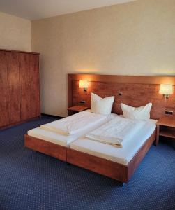 伯格奥夫费马恩NP Hotel Wissers的一张大床,位于酒店带两盏灯的房间