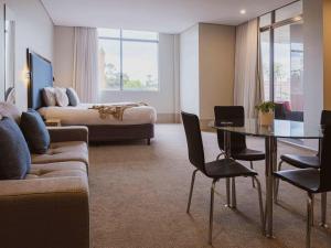 麦夸里港麦夸里港中心美居酒店的酒店客房设有沙发、桌子和床。