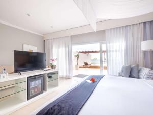 瓜鲁雅Hotel Jequitimar Guaruja Resort & Spa by Accor - Ex Sofitel的卧室配有一张白色大床和电视。