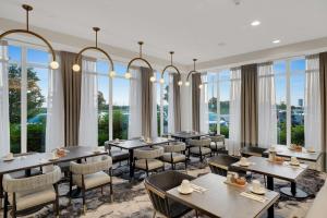 布兰普顿多伦多/宾顿希尔顿花园酒店的餐厅设有桌椅和窗户。