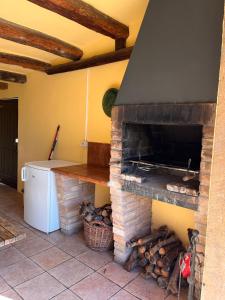 普奇雷奇Cal Colom的厨房配有砖炉和一堆木头