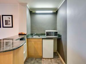 墨尔本北墨尔本美居酒店的厨房配有水槽和台面上的微波炉