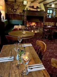 YoulgreaveFarmyard Inn的餐厅内一张桌子、酒杯和壁炉