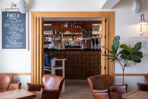 索尔科姆South Sands Hotel的一间带酒吧的餐厅,设有木门