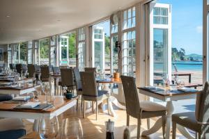 索尔科姆South Sands Hotel的餐厅设有桌椅和窗户。