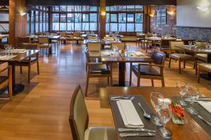 圣卡洛斯-德巴里洛切NH巴里洛切雪绒花酒店的餐厅设有木桌、桌椅和椅子
