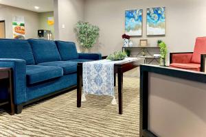 威斯康星戴尔Quality Inn & Suites Wisconsin Dells Downtown - Waterparks Area的客厅配有蓝色的沙发和桌子