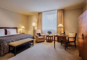 威斯巴登纳索尔霍夫酒店的酒店客房,配有一张床、一张桌子和椅子