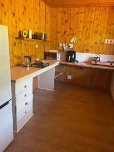 Albert FallsHoopoe log cabin的厨房设有木墙和白色台面