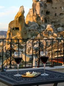 格雷梅卡帕多西亚卡内拉卡威酒店的享有美景的桌子上放着两杯葡萄酒