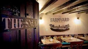 YoulgreaveFarmyard Inn的一间设有两张桌子的餐厅,墙上有标志