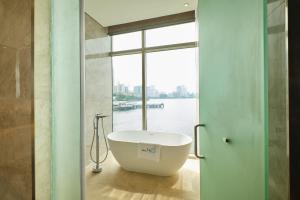 马尼拉H2O酒店的窗户前设有带浴缸的浴室