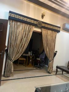 GujrātWarraich villa gt raod gujrat entire的客厅的墙壁上设有窗帘