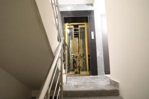 海得拉巴The Nectar Hotel的大楼内带金色电梯的楼梯
