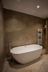 斯库台Duomo Resort的浴室内设有大型白色浴缸。