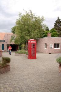 鲁汶Room in Apartment - Condo Gardens Leuven - Student Flat Semiduplex的砖路上的一个红色电话亭