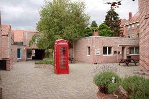 鲁汶Room in Apartment - Condo Gardens Leuven - Student Flat Semiduplex的庭院里的一个旧红色电话亭