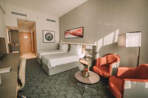 迪拜Peony Hotel的酒店客房配有一张床、一张沙发和椅子。