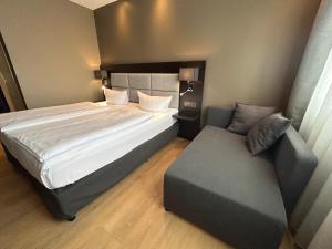 卡尔斯鲁厄卡尔门酒店的一间卧室配有一张大床和一张沙发
