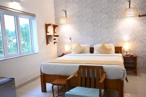 蓬蒂切里AURA HOTEL的一间卧室设有一张大床和一个窗户。