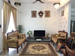 峇冬加里As Salam Musliim Homestay的客厅配有平面电视和椅子