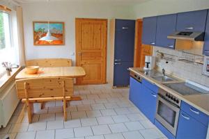 普鲁滕Ferienwohnungen Pruchten VORP 1164的厨房配有蓝色橱柜和木桌