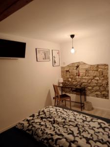 阿奎莱亚Amnis的一间卧室配有一张床、一张桌子和石墙