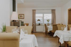 弗拉绍B&B Hotel Die Bergquelle的餐厅设有白色的桌椅和窗户。