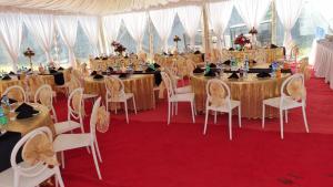 基苏木Balmoral Beach Hotel Kisumu的帐篷内的宴会厅配有桌椅