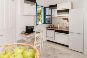 阿波罗尼亚Green Apple的厨房配有白色橱柜和一篮苹果