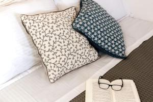 阿波罗尼亚Green Apple的床上的书和眼镜,带枕头